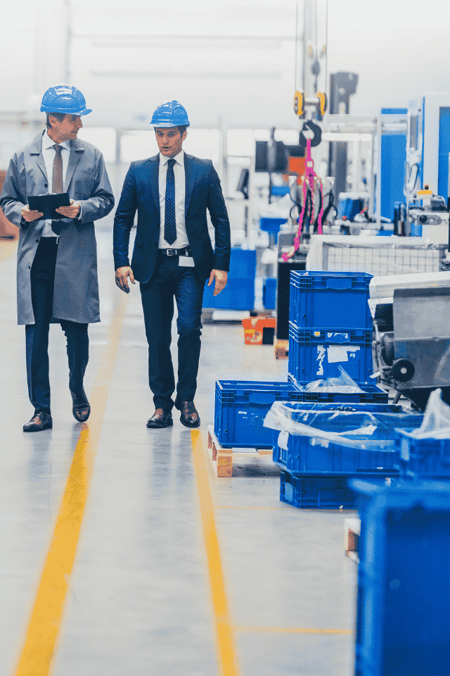imagen de empresarios caminando por una fábrica dos emprendedores caminan por su fábrica y dan el visto bueno a la producción. Ambos pertenecen a DGI